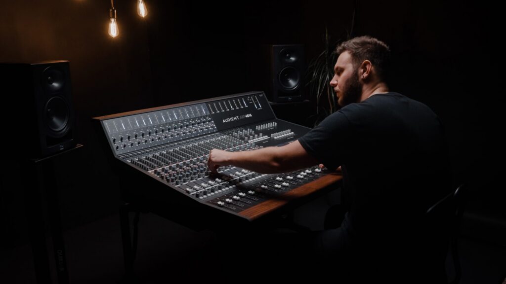 Engineer operating an analog mixing console where maintenance and care preserve performance